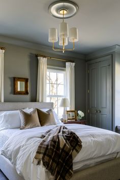 a bed with white sheets and pillows in a bedroom