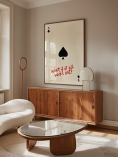 a living room filled with furniture and a painting on the wall over a coffee table