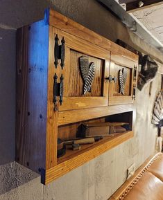 a wooden cabinet with several different types of shoes on it's sides and some leather seats in front of it