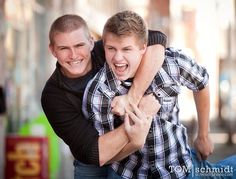 two young men hugging each other on the street