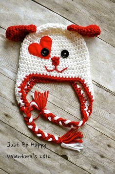 a crocheted hat with a red and white bear on the front is shown