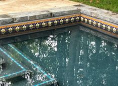 an empty swimming pool surrounded by green grass