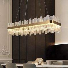 a chandelier hanging over a dining room table with chairs and tables in front of it