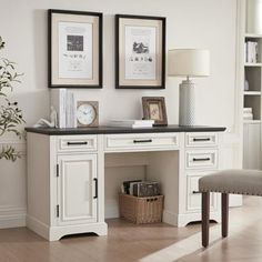 a white desk with two framed pictures above it