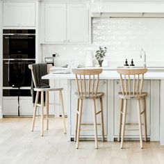 two wooden chairs sitting in front of a kitchen island