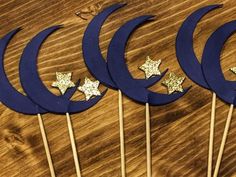 five blue and gold stars on toothpicks sitting on top of a wooden table