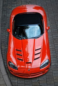 an orange sports car is parked on the street