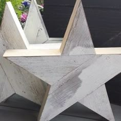 a white wooden star sitting on top of a window sill