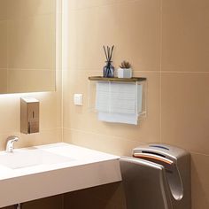 a bathroom with a sink, mirror and toilet paper dispenser