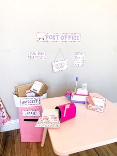 a pink table topped with lots of mail boxes and post office magnets on the wall