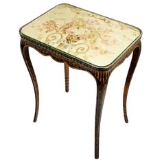 an ornately decorated side table with flowers on the top and bottom, against a white background