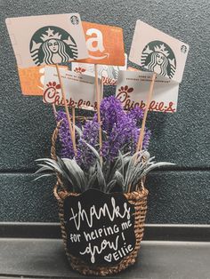 a basket filled with purple flowers sitting on top of a counter next to a starbucks sign