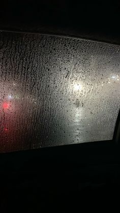 rain drops on the windshield of a car at night