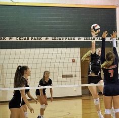 the volleyball players are trying to hit the ball