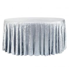 a round table covered in silver crushed velvet fabric with a circular skirt on the top