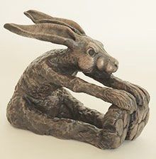 a statue of a rabbit sitting on its hind legs with it's hands together