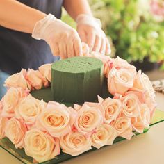 a woman is decorating a cake with flowers