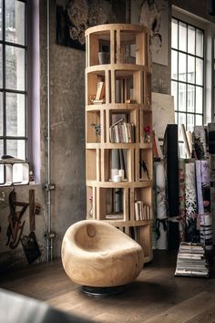 a wooden chair sitting on top of a hard wood floor next to a bookshelf