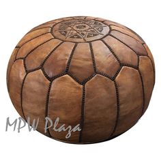 a large brown leather poufce sitting on top of a white surface