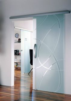 an open glass door in a white room with wood flooring and hard wood floors