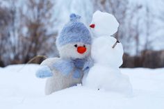 there is a snowman and a teddy bear in the snow