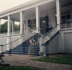 an old house with people walking up the stairs