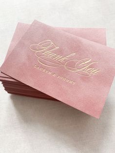 four pink business cards with gold foil on the front and back, sitting on top of each other