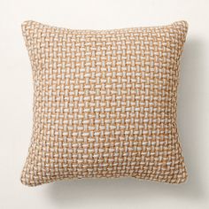 a brown and white pillow sitting on top of a white wall