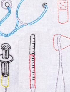 embroidered medical items on white fabric with red and blue thread