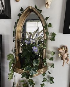 there is a mirror and some plants on the wall