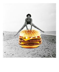 a woman standing on top of a giant hamburger in the middle of a sandy beach