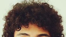 a close up of a person with curly hair