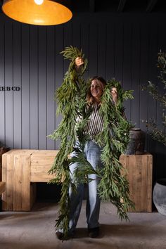 a woman is holding some plants in her hands