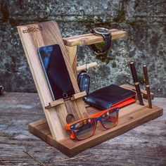 a wooden stand with glasses, cell phone and other items