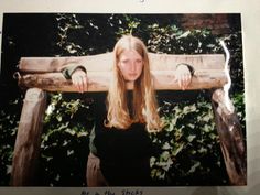 a woman is holding on to a wooden bench