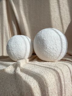 two white balls sitting on top of a blanket