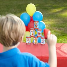 a young boy is playing with his toys at a birthday party in the park on a sunny day