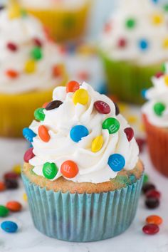 cupcakes with white frosting and sprinkles on a cooling rack