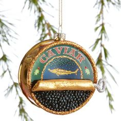 a christmas ornament hanging from a pine tree with the name caviar on it