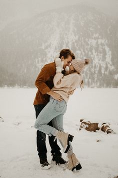 a man and woman kissing in the snow