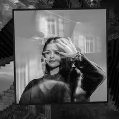 a black and white photo of a woman holding her hand up