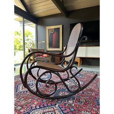 a rocking chair on top of a rug in a living room