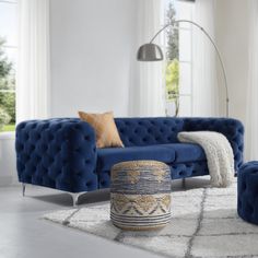 a living room with blue couches and white rugs