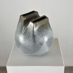 a silver vase sitting on top of a white box