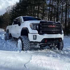 a white truck is driving through the snow