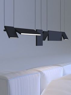 three suspended lights above a bed in a room