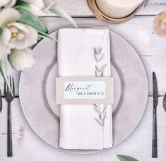 a place setting with napkins, silverware and flowers