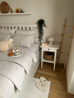 a bed with white sheets and pillows in a bedroom