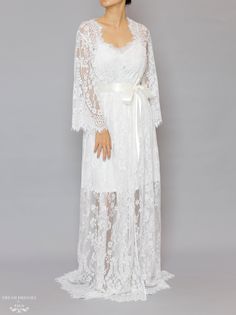 Floor length bridal lace robe with Chantilly French lace Length: 160 cm / 62 in Loose-fitting Bell sleeves Silky ribbon belt Scalloped neckline, lace cuffs and hemline Model is 160 cm/ 5'3'' and wearing a size S Luxury Long Sleeve Lace Dress With Lace Cuffs, Luxury Long Sleeve Feminine Robe, Luxury Long-sleeve Lace Dress With Lace Cuffs, Luxury Romantic Dress With Lace Cuffs, Luxury Long Romantic Robe, Luxury Romantic Lace Dress With Lace Cuffs, Luxury Fitted Lace Dress With Lace Cuffs, Elegant Lace Bridal Gown, Elegant Bridal Lace Gown