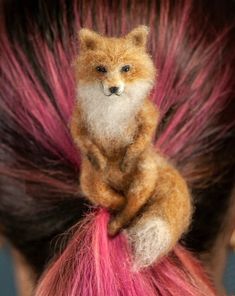 a small stuffed animal sitting on top of a woman's head with pink hair